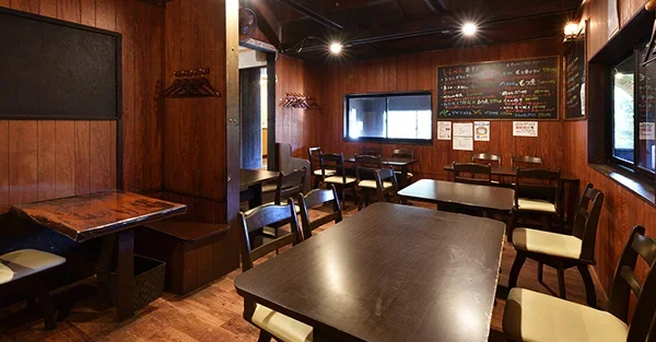 木の温もりあふれるテーブル席が並ぶ田舎レストランじんべえの店内